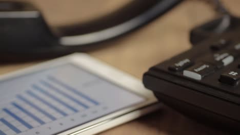 Office-phone-and-tablet-with-blue-bar-chart-displayed-on-screen