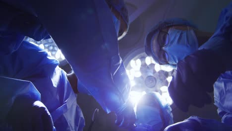 surgeons wearing face masks holding surgical instruments in operating theatre