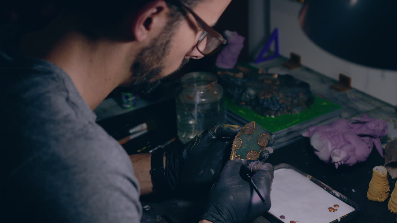 taller de pintura hombre pintando un pequeño objeto impreso en 3d medio tiro