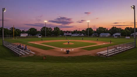 a stunning transition from dusk to night: a baseball field illuminated as players and spectators enjoy an evening game under the twilight sky