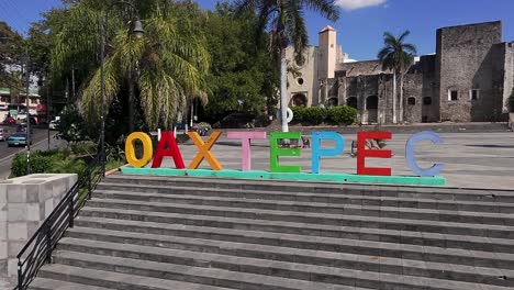 backward dolly shot of oaxtepec sign and historic convent capilla de san miguel in tlayacapan, morelos, mexico