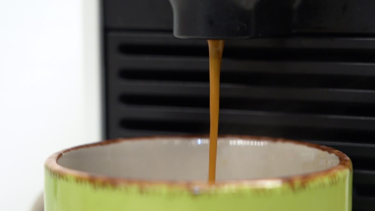 Fresh Hot Coffee Elegantly Pouring Into Green Mug From Espresso Machine Close Up In Slow Motion