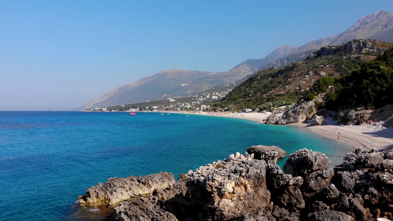 Paradise beach surrounded by cliffs washed by calm clear water of azure Mediterranean sea in Albania