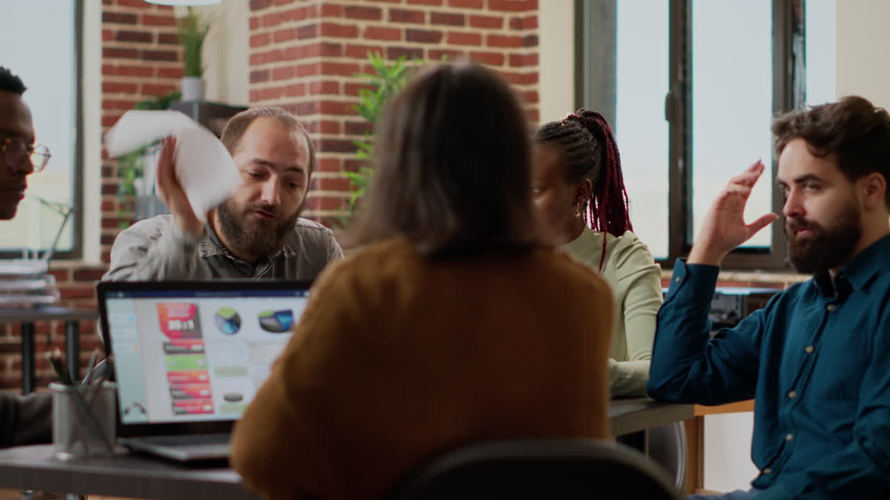 Aggressive manager being angry and throwing papers at employees