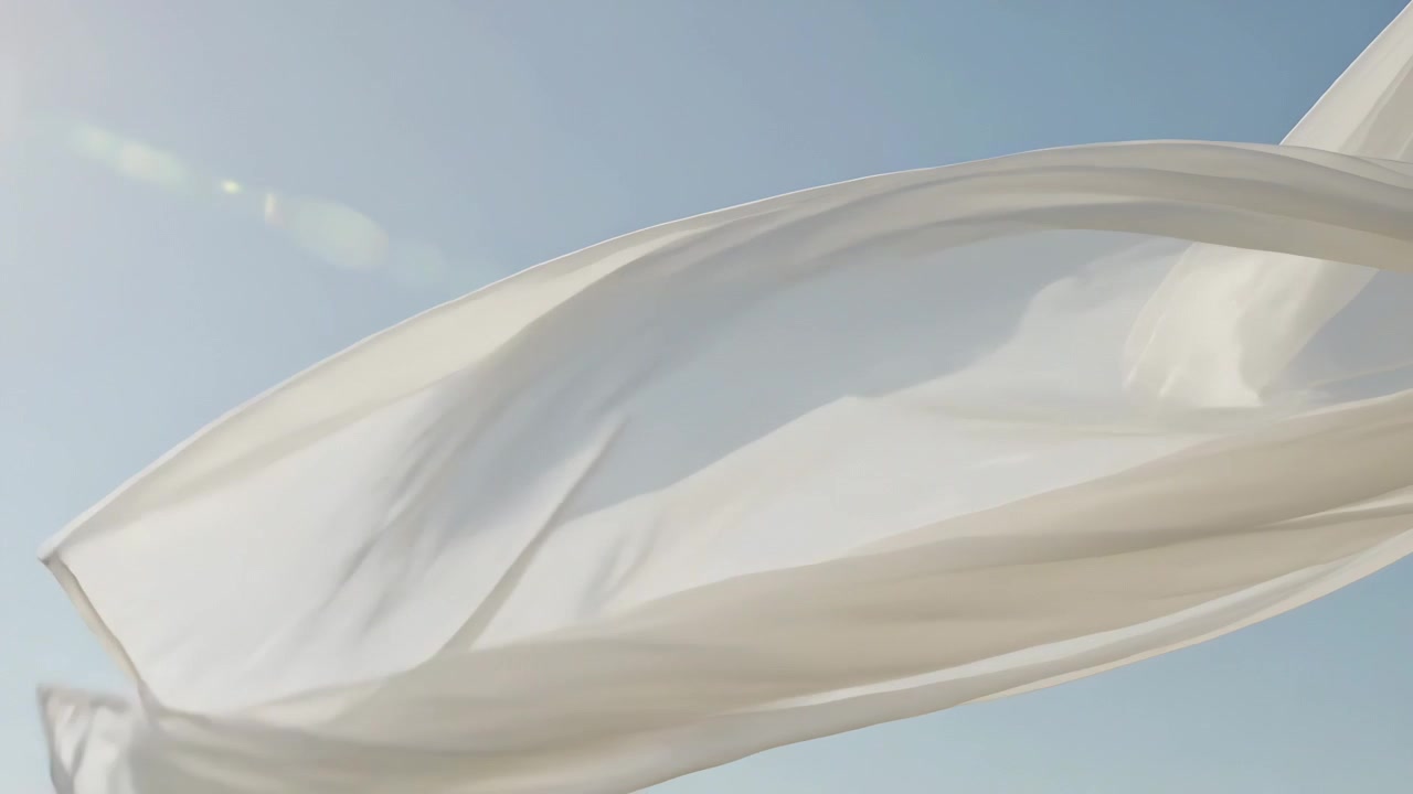 Gusts pushing lightweight white translucent fabric unfurling across clear blue sky, sun lens flare