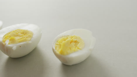 video of close up of three halves of hard boiled eggs on grey background