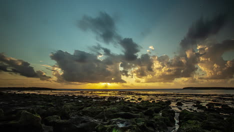 nubes oscuras que pasan sobre una hermosa puesta de sol naranja amarilla a orillas de un lago