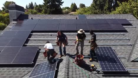 a team of four hardworking individuals is installing solar panels on a rooftop under clear blue skies. they carefully handle equipment and collaborate to ensure successful installation on a sunny day.
