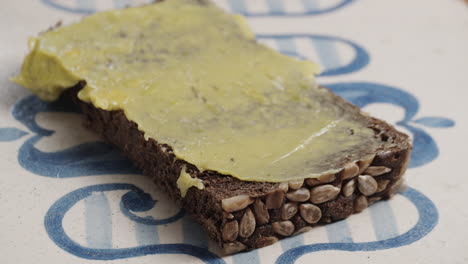 Avocadoaufstrich-Auf-Dem-Stück-Dunklem-Brot