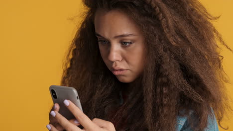 caucasian curly haired woman scrolling on smartphone.