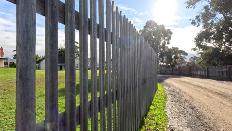 a sunny walk along a fenced path