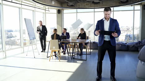 portrait of a businessman with a folder throwing papers. business partners work in office center. young colleagues sitting at the table and discussing business work.