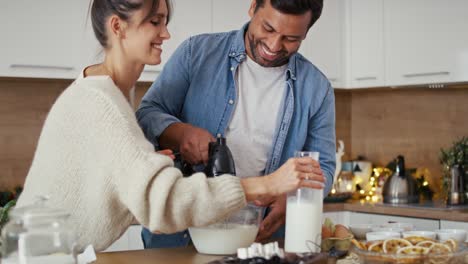 una pareja multiétnica haciendo un pastel juntos en navidad.