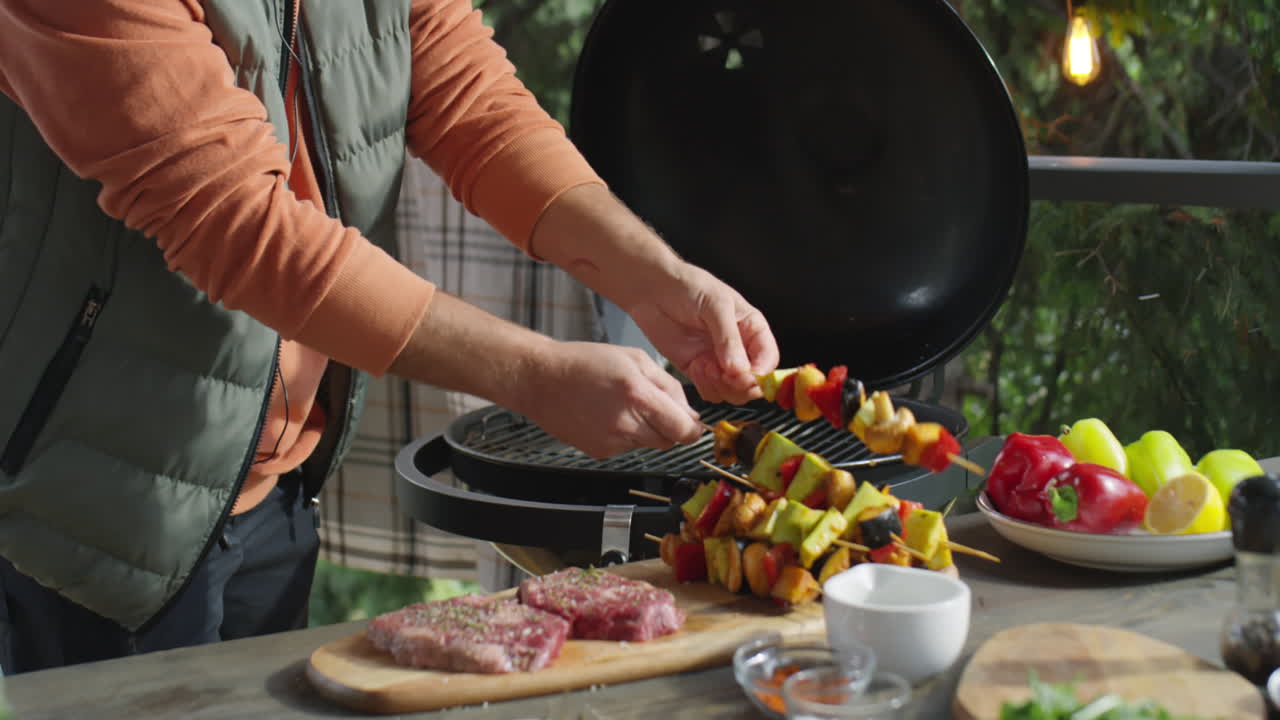 Food blogger che cucina spiedini di verdure al barbecue sulla terrazza