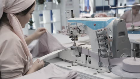 woman sewing on an industrial sewing machine in a textile factory