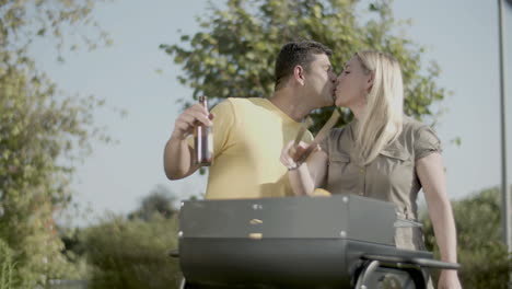 happy mid adult couple cooking food on barbecue grill together