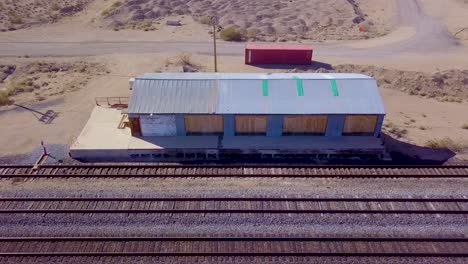 aerial view backing away from abandoned railroad depot and tracks