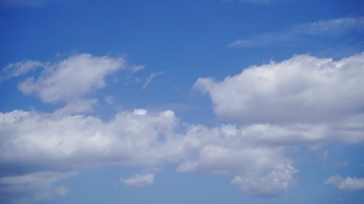 Fluffy White Clouds Moving In The Bright Blue Sky In The Afternoon - timelapse