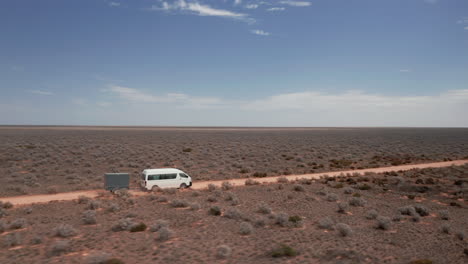 aerial view around a rv van and a trailer, driving in a endless desert wilderness - circling, drone shot