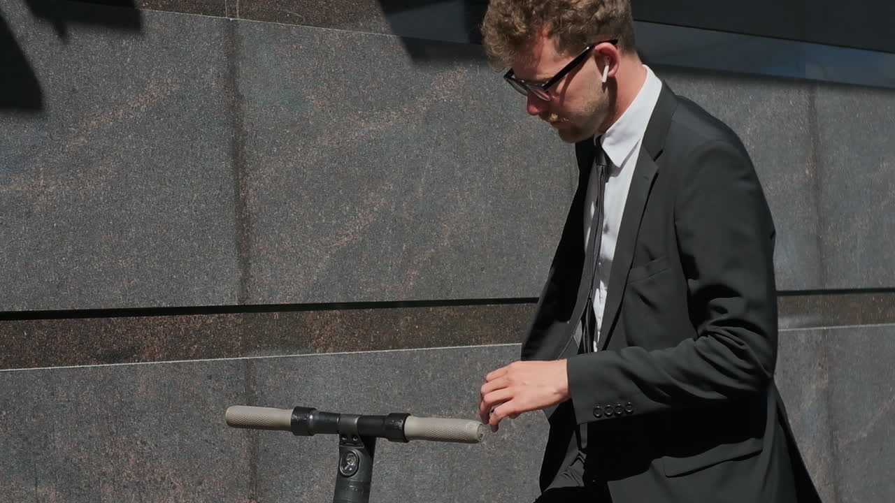 전기 스쿠터 에 스마트폰을 사용하는 사업가