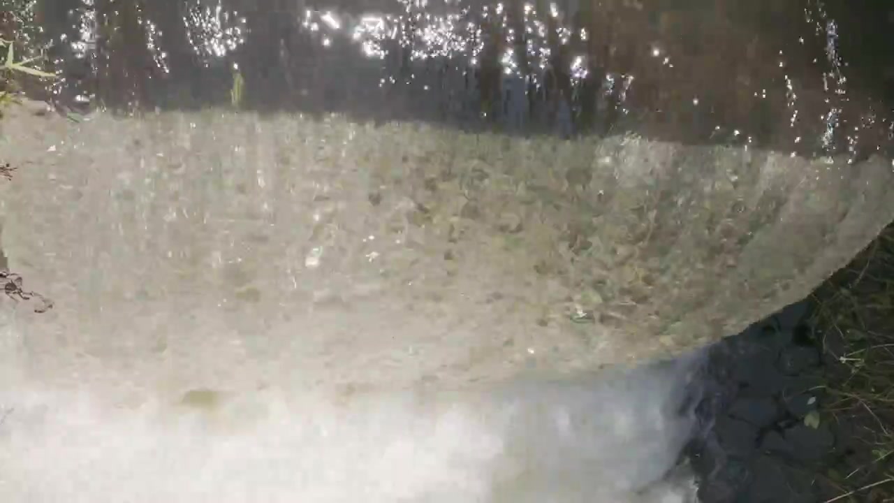 Primo piano dell'acqua che scorre su una piccola diga.