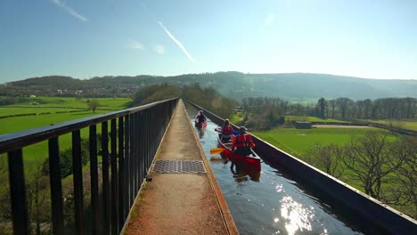 a kayak, canoe instructor takes his clients over the famous pontcysyllte aqueduct on the llangollen canal situated in north wales, outdoors extreme sports