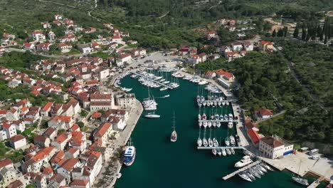 Vista-Aérea-De-Yates-Y-Barcos-En-El-Embarcadero-Con-El-Pueblo-De-Milna-En-La-Isla-De-Brac-En-Croacia