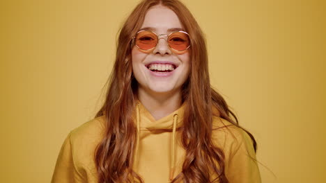 smiling woman acting indoors. female person laughing on orange background