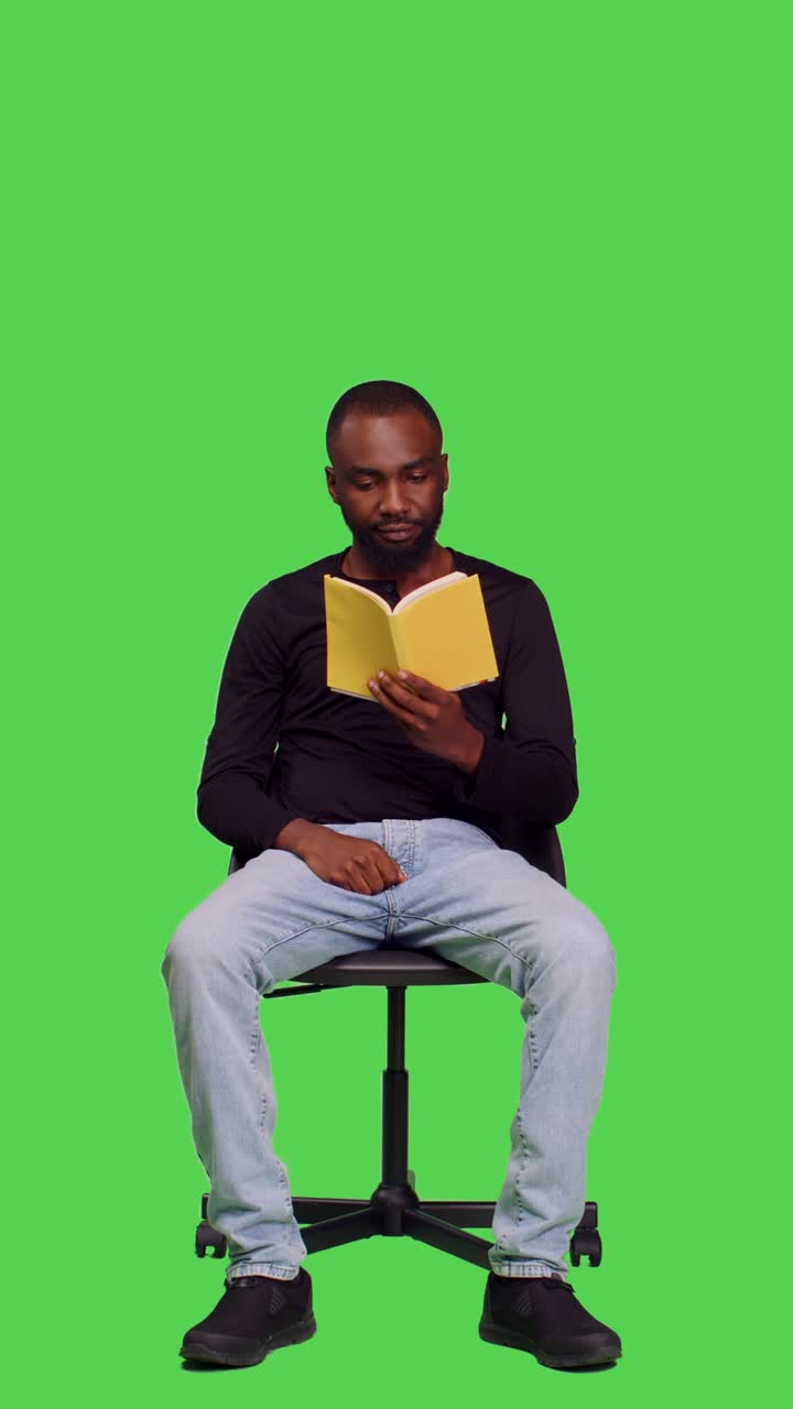 Vertical video: Front view of focused person reading story tale book in studio