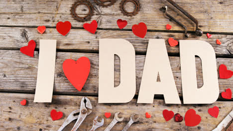 Text-I-love-dad-with-red-hearts-and-old-work-tool-on-wooden-plank