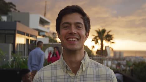 young man smiling at camera on a rooftop