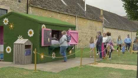 queue of people at small shop social distancing after lockdown ends