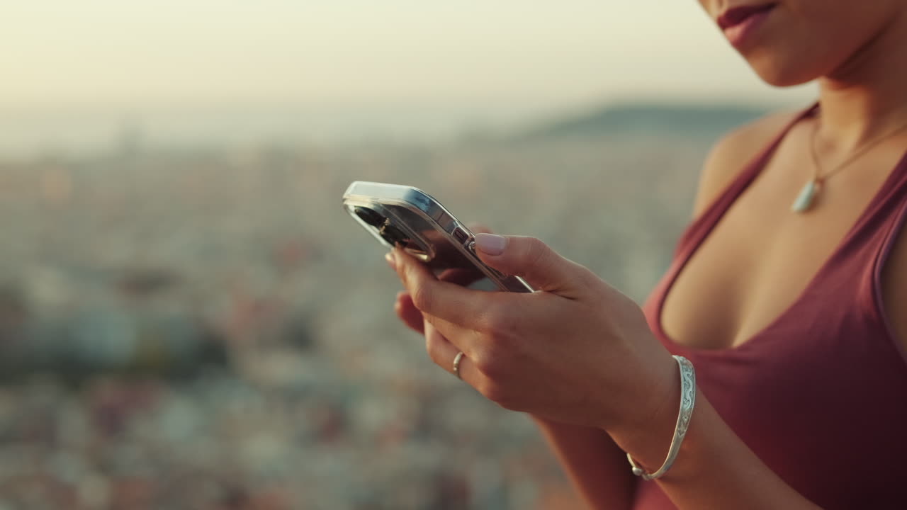 Donna che usa un telefono cellulare con vista sul panorama della città