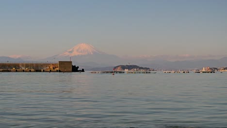 panning shot over ocean with mount fuji and enoshima island in background