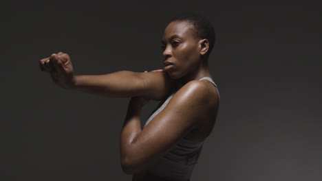 Studio-Shot-Of-Young-Woman-Wearing-Gym-Fitness-Clothing-Warming-Up-For-Exercise