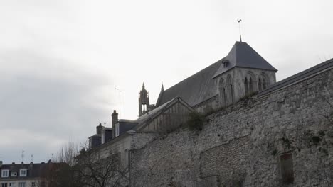 vista en ángulo lateral de la vieja pared de roca desgastada que protege los grandes edificios oficiales en vernon, francia
