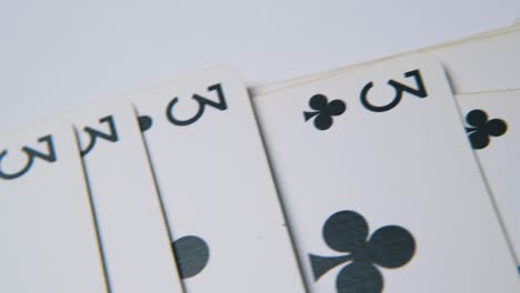 motion over club playing cards on empty white surface