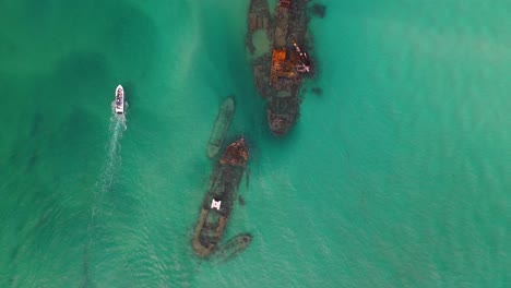 boats exploring shipwrecks off moreton island, australia, aerial top down view