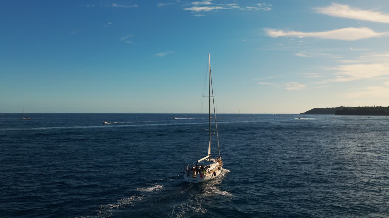 Vista aerea che segue una barca a vela che naviga nel Golfo di Napoli, tramonto in Italia