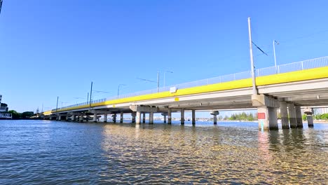 boat travels under bridge in gold coast, australia