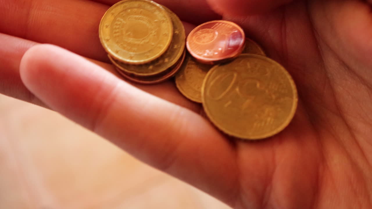 4 k hombre caucásico con monedas de euro en sus manos