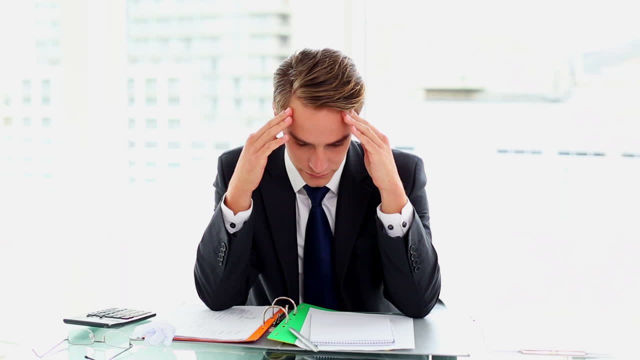 Desperate attractive businessman working sitting at his desk