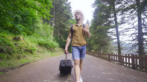 male tourist carrying his suitcase.