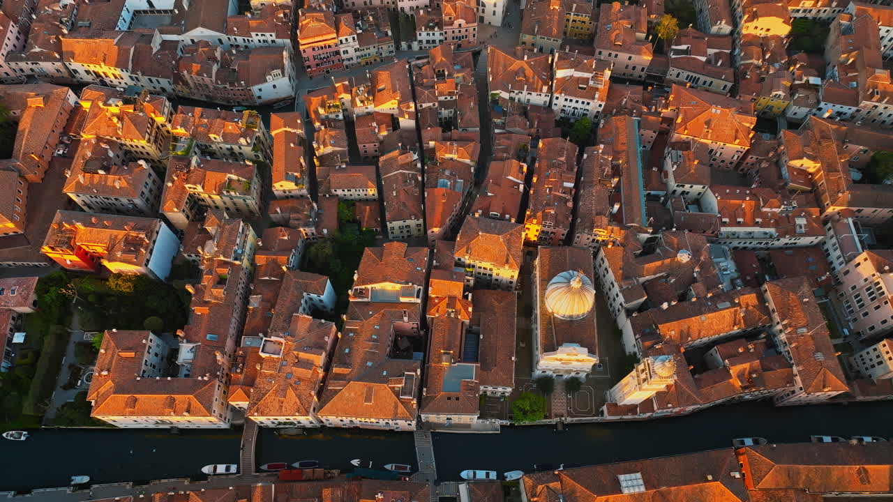 Straight down Aerial drone shot of houses surrounding The Basilica di Santa Maria Gloriosa dei Frari rooftop in Venice, Italy