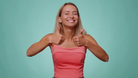 mujer encantadora levanta los pulgares está de acuerdo o da una respuesta positiva recomienda el anuncio le gusta bien