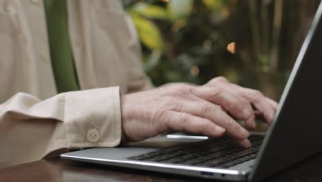 Nahaufnahme-Der-Hände-älterer-Männer,-Die-Langsam-Auf-Der-Tastatur-Des-Laptops-Tippen