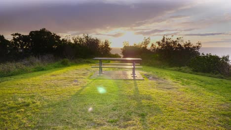 Leerer-Picknicktisch-Am-Crescent-Head---Helles-Sonnenlicht,-Das-über-Das-Meer-Und-Die-Küstenberge-Scheint---Sydney,-Nsw,-Australien