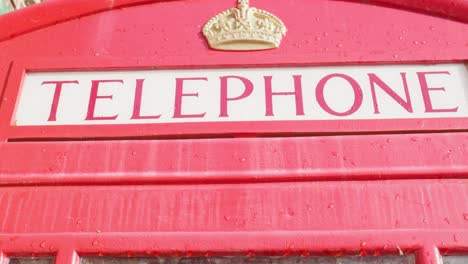 iconic red british k6 telephone box kiosk in rain close up upper part