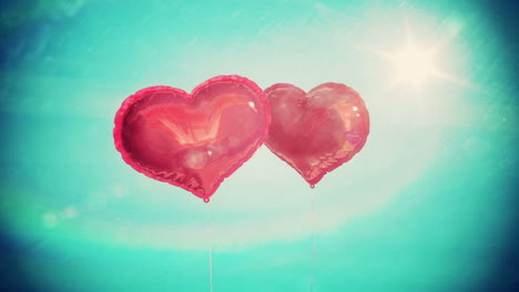 heart balloons floating against blue sky