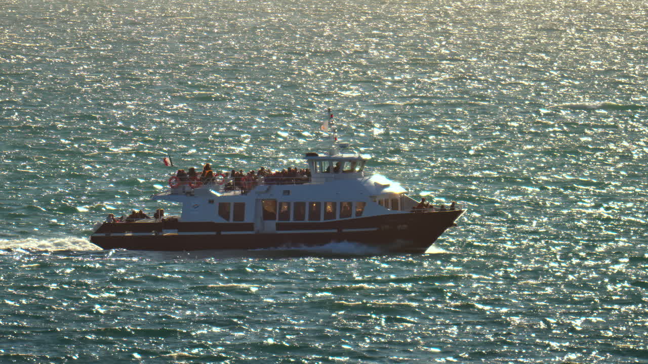 Boat filled with people moving on the sea on a sunny day